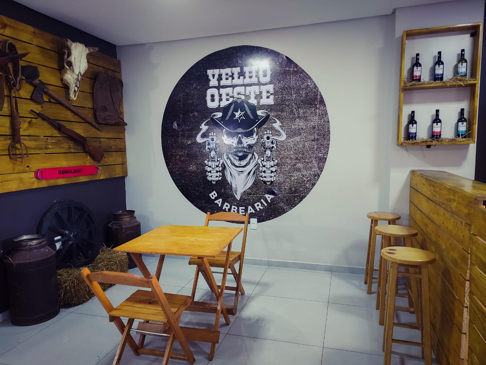 Parede com logo e decoração western da Velho Oeste Barbearia